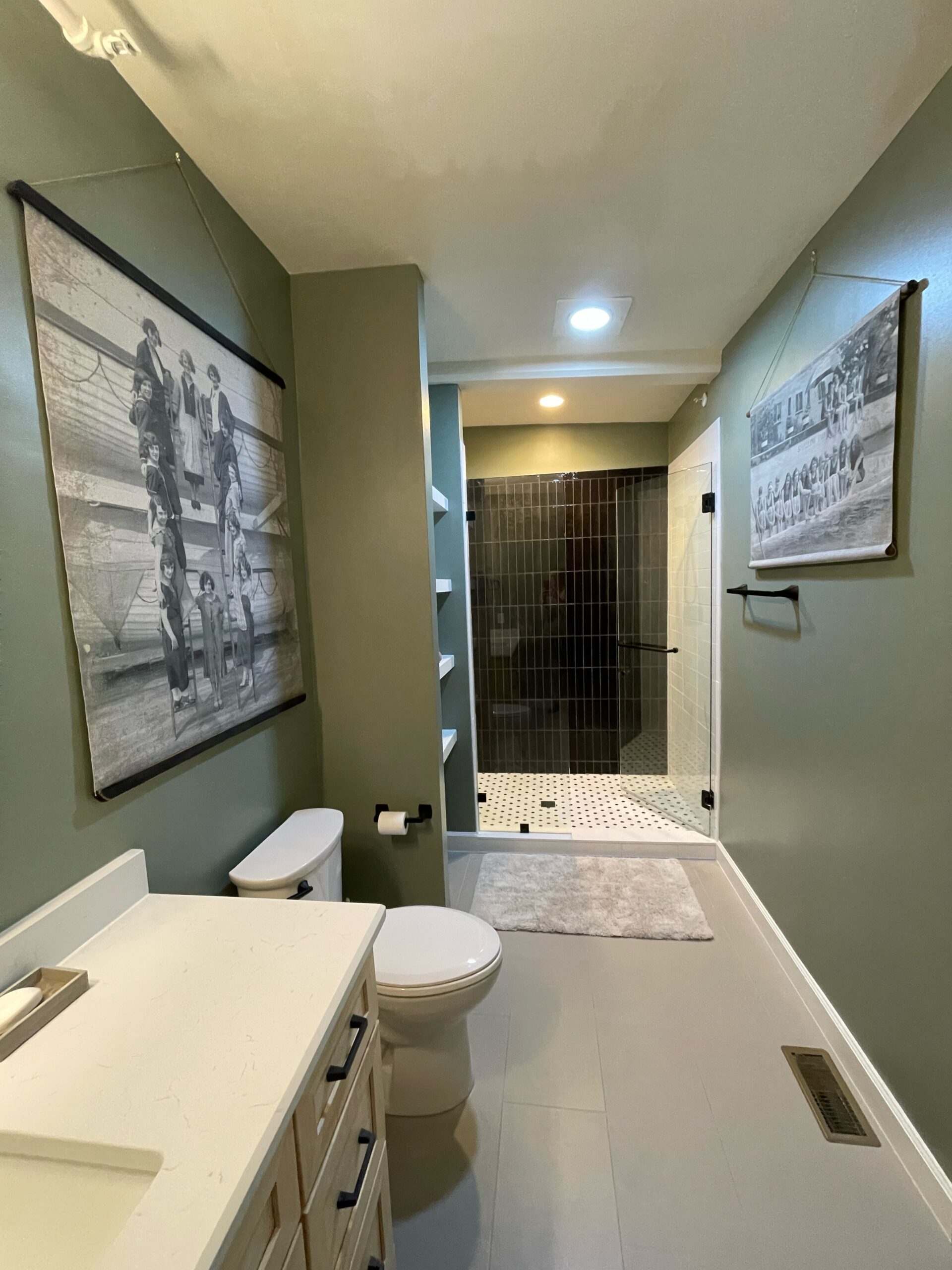 Completed bathroom remodel with a finished shower, vanity, tile, fixtures, and coordinated materials