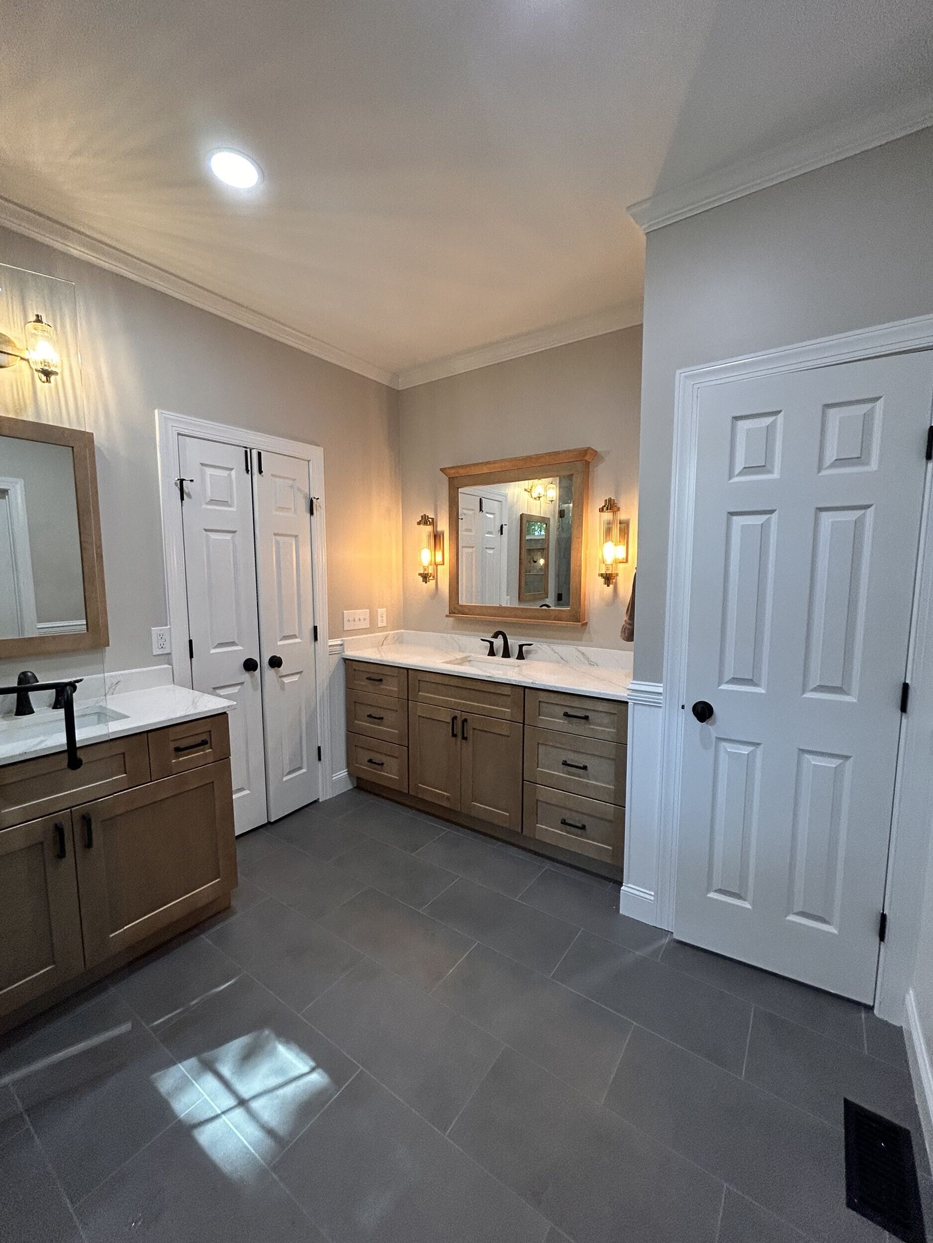 Completed bathroom renovation showing coordinated materials, storage, fixtures, lighting, and layout decisions